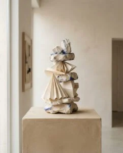 Sculpture claire aux plis empilés, posée sur un socle, œuvre d’Anaïs Duval